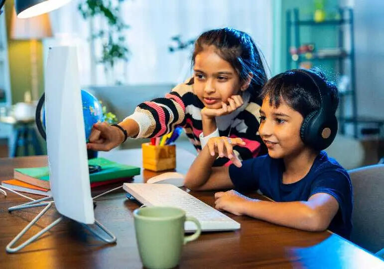 Student taking part in online learning session with sister supporting
